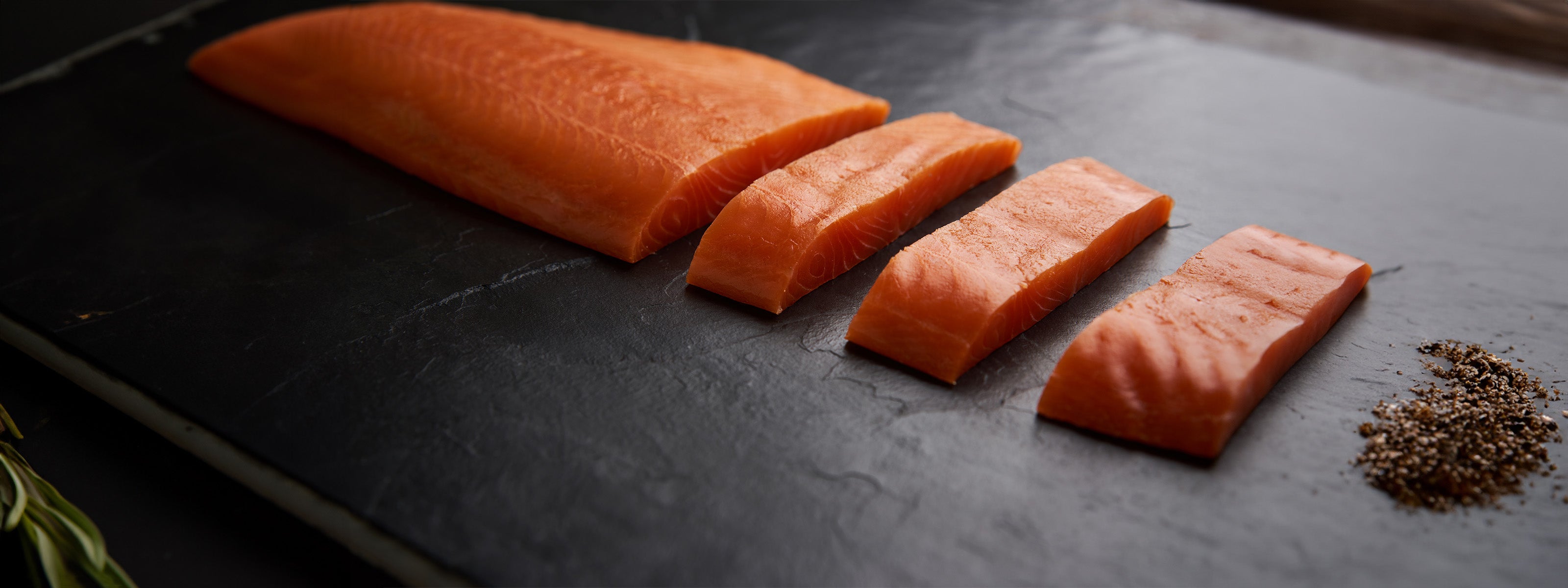 Salmon portions from Bakkafrost laid out on a black plate